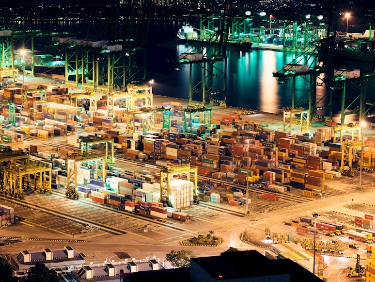 High-resolution nighttime aerial view of a major container terminal, illustrating global logistics infrastructure.